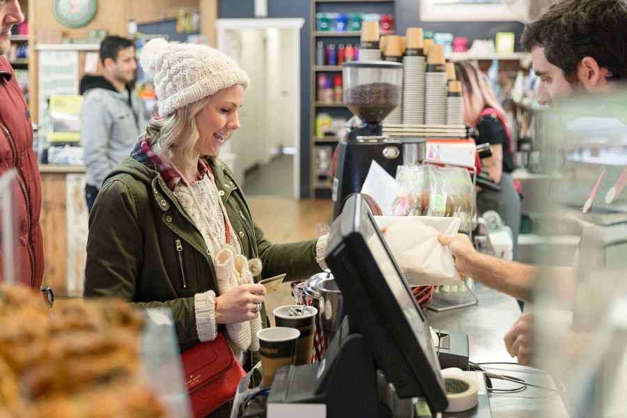 Vrouw rekent koffie en iets lekkers erbij af in restaurant