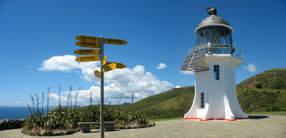 Zicht op de vuurtoren bij Cape Reinga en een richtingaanwijzer