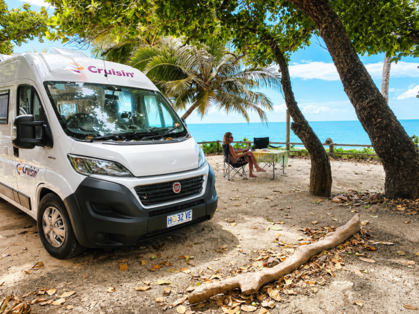 Kamperen met de Cruisin' Sandpiper aan het strand, man zit aan tafel buiten
