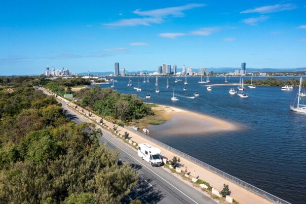 Mighty Double Up camper rijdt in dronebeeld langs de skyline van de Gold Coast