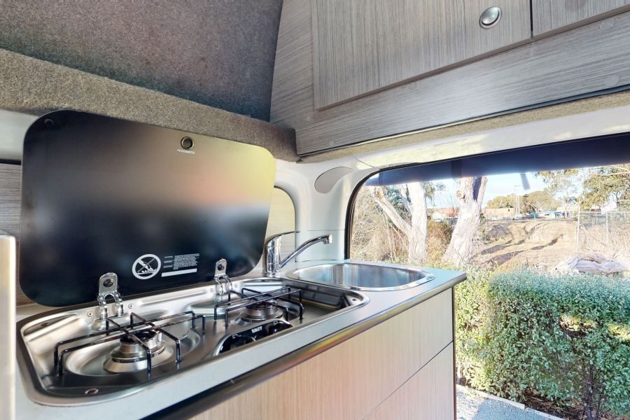 Zicht op de keuken en het gasfornuis van de Go Cheap 4 Berth Hitop, met de achterklep open