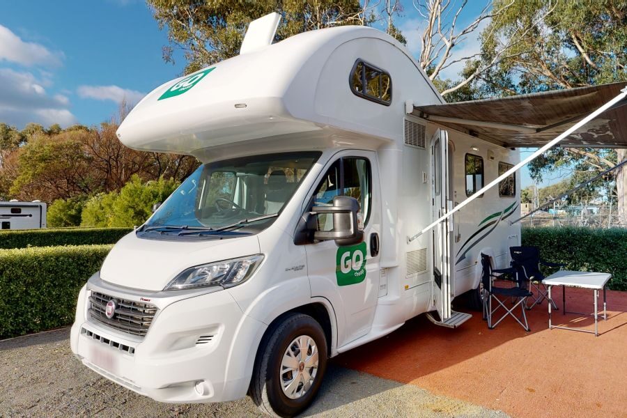 Go Cheap Henty staat geparkeerd op een camping, de luifel is uitgeklapt en de stoelen staan buiten