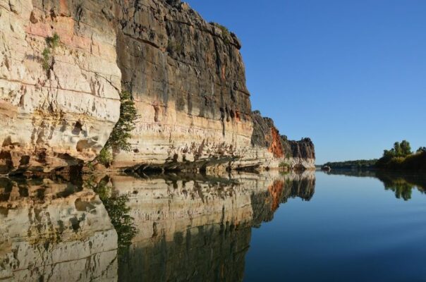 Zicht op gekleurde rotsen met reflectie in het water in de Geiki Gorge in de Kimberley