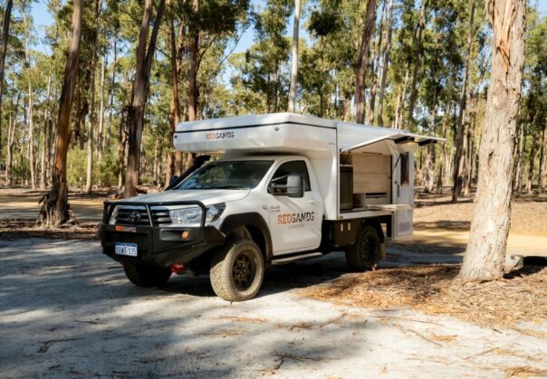 RedSands Wanderer Luxe camper staat geparkeerd in bos met keukenluik open
