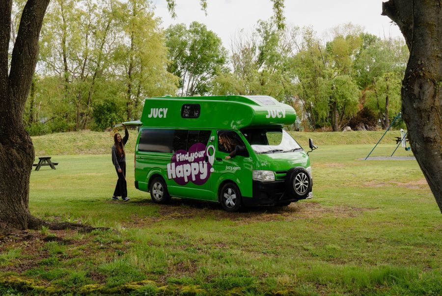 Jucy Chaser geparkeerd tussen bomen op een camping en wordt uitgepakt