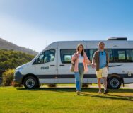 Man en vrouw lopen hand in hand weg van de Maui Ultima camper in de Yarra Valley