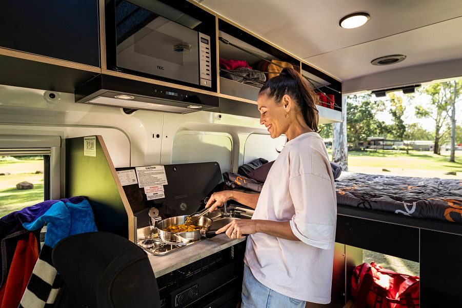 Vrouw is aan het koken in de Britz Hitop camper