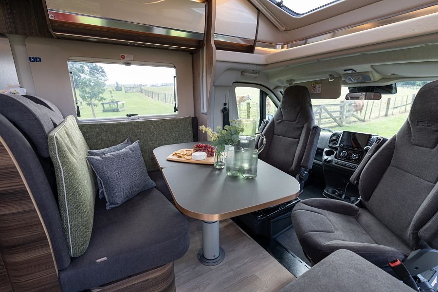 Het zitgedeelte van de Britz Wanderer camper met tafel, bankje en twee draaibare stoelen in de cabine