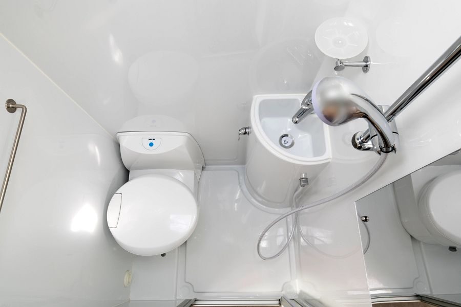 De badkamer met toilet, wasbak en douche in de Maui Cascade camper