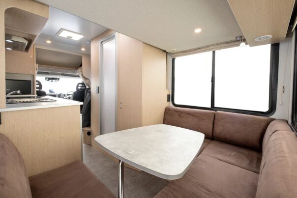 De zithoek achterin de Maui Cascade camper met tafel kijkend naar de voorkant van de camper