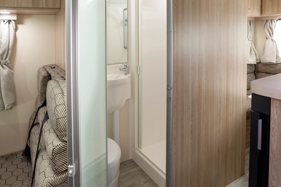 Het interieur van de Mighty Double Up camper met de badkamerdeur open