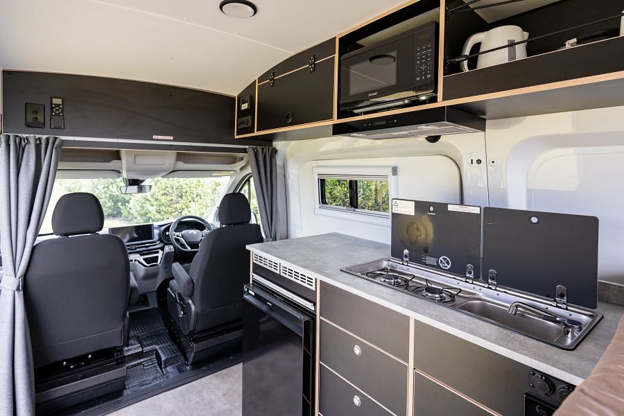 Het interieur met keukenblok en bestuurdersruimte van de Mighty Lite HiLITE camper in Nieuw-Zeeland