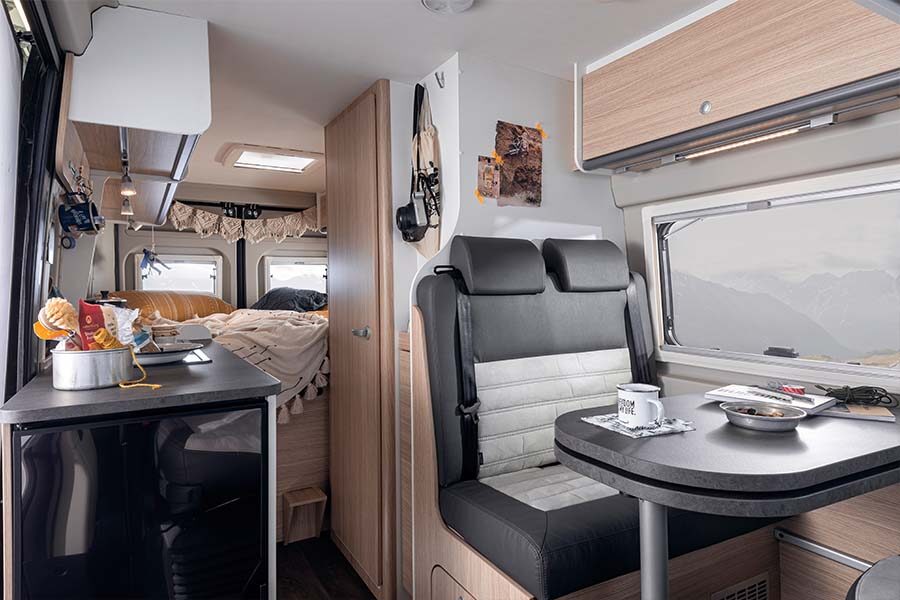 Het interieur van de McRent Urban Plus camper in Nieuw-Zeeland met zitgedeelte, keuken en achterin het tweepersoonsbed