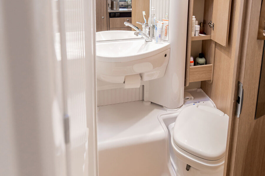 De badkamer met toilet en wasbak in de McRent Family Standard camper