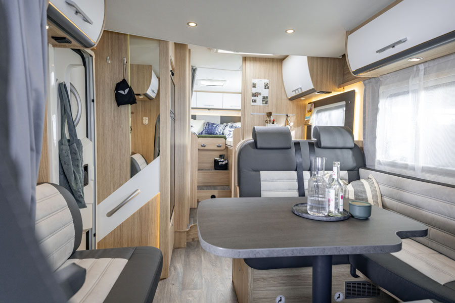 Het interieur met zithoek kijkend van voor naar achter in de McRent Family Luxury motorhome