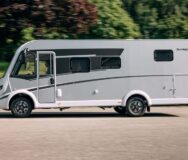 Een man rijdt in de McRent Comfort Luxury vanaf de zijkant gezien