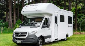 De voor- en zijkant van de Pacific Horizon Gem 4 camper geparkeerd op een grasveld in Nieuw-Zeeland