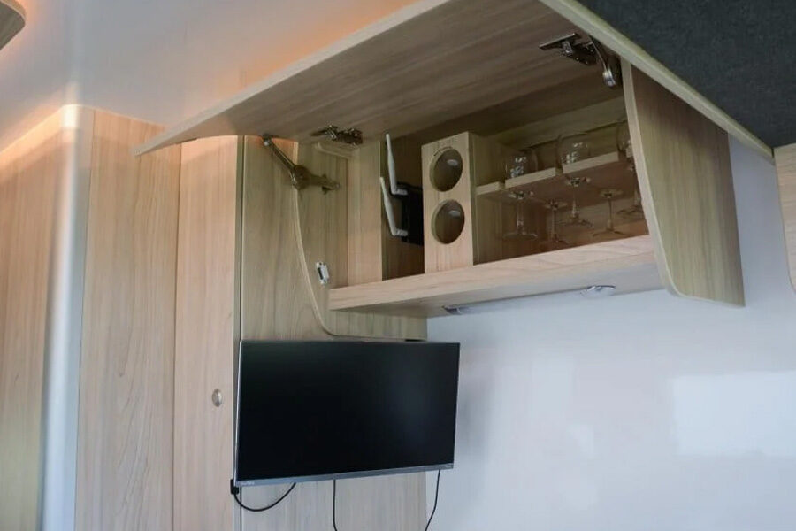 Boven de TV is een kast voor wijnglazen in de Pacific Horizon Sam 6 camper Nieuw-Zeeland