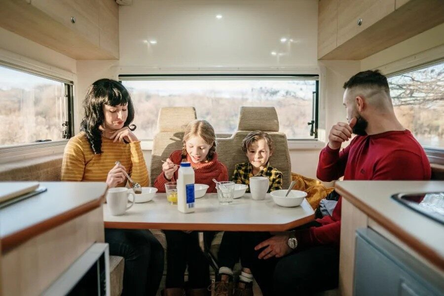 Gezin is aan het ontbijten in de zithoek van de Leisure Rent 4 Berth Motorhome