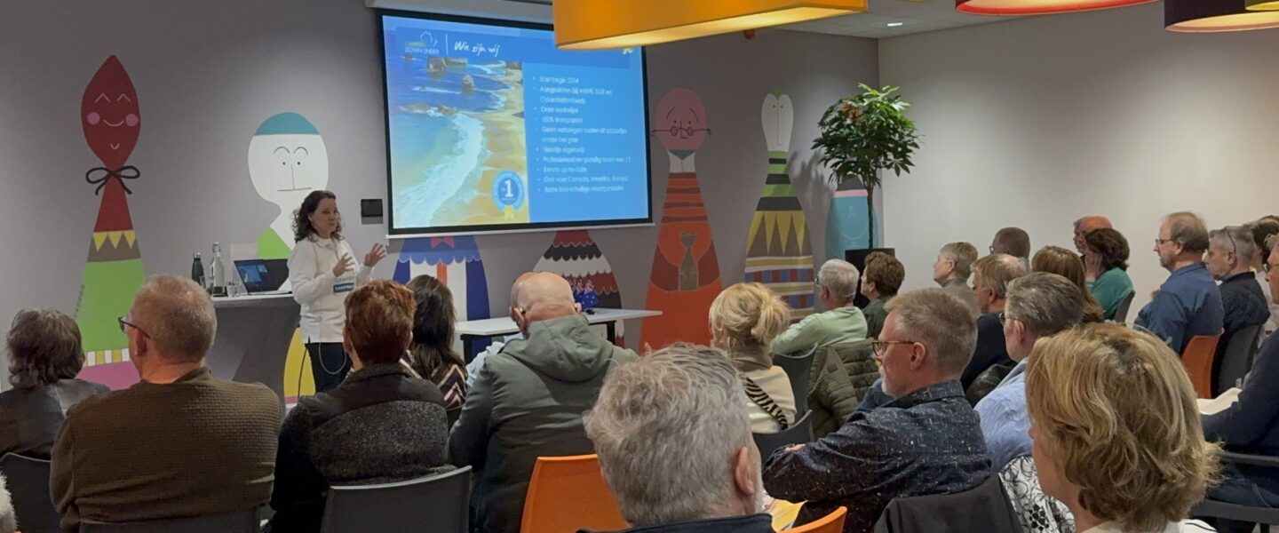 Informatiedag Campers Down Under, zaal vol met gasten, Karin presenteert
