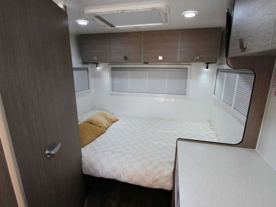 Het bed achterin de Leisure Rent Deluxe Motorhome is opgemaakt