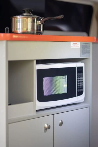 Een pan en magnetron in de keuken van de Travellers Autobarn Hi5