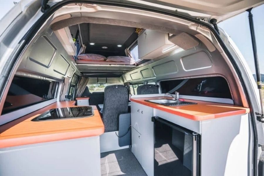 Zicht op de keuken en het interieur van de Travellers Autobarn Hi5 vanuit de open achterklep