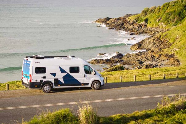 De Star RV Polaris 2 camper staat geparkeerd naast een weg langs de kust met uitzicht op zee