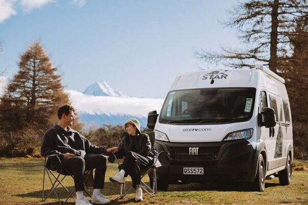 Een koppel zit op de campingstoelen voor de Star RV Polaris 2 camper tijdens het kamperen in Nieuw-Zeeland