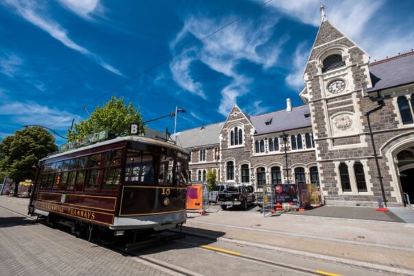 Tram rijdt langs oud gebouw in Christchurch Nieuw-Zeeland
