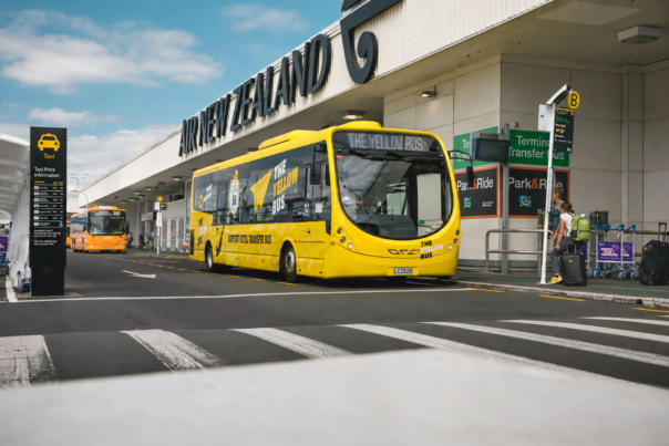 De Yellow Bus staat geparkeerd voor de luchthaven in Auckland