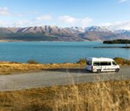 De Maui Ultima rijdt over een weg langs Lake Wanaka met uitzicht op de bergen