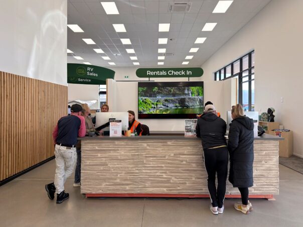 Mensen staan aan de balie van de verhuurder om hun camper op te halen