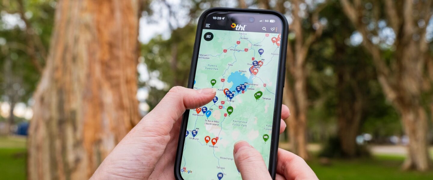 Man kijkt op THL roadapp op zijn telefoon