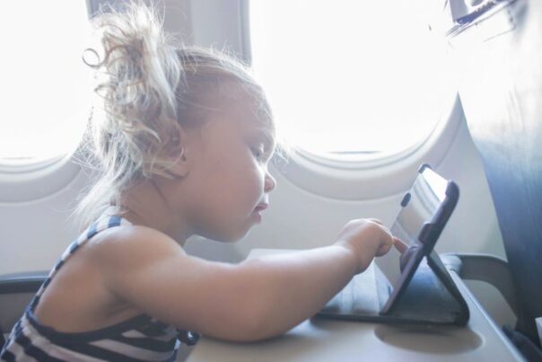 Kind speelt spelletje op een tablet in het vliegtuig