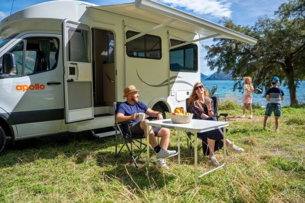 Gezin kampeert met Apollo Euro Quest in Nieuw-Zeeland, kinderen doen een spel, ouders zitten aan tafel