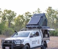 Adventure Rentals Toyota Hilux 4WD met enkele Daktent staat geparkeerd met de tent open en het zonnepaneel zichtbaar